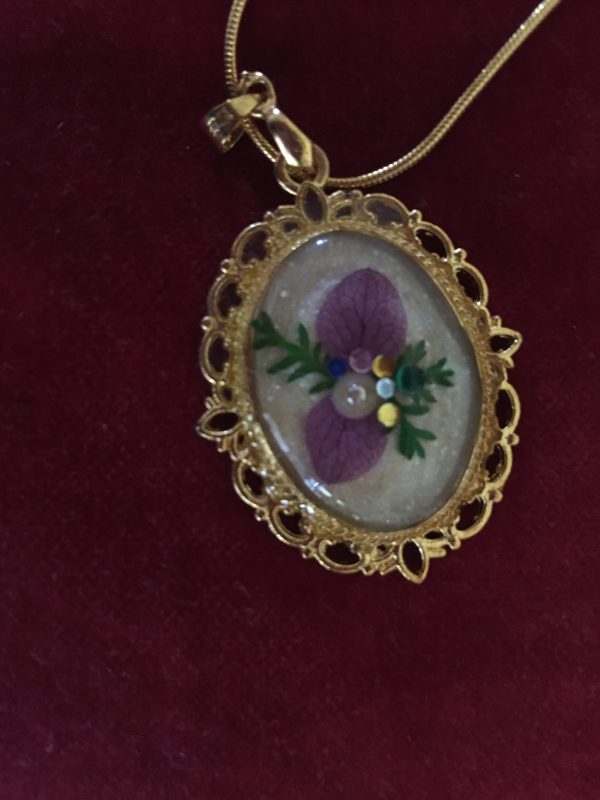pendentif doré avec fleur et réalisé en résine